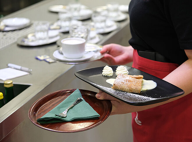 Serviererin mit Gabel und Apfelstrudel in der Hand