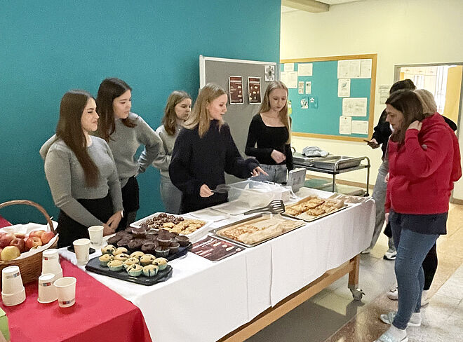 Schülerinnen verkaufen in der großen Pause Apfelprodukte