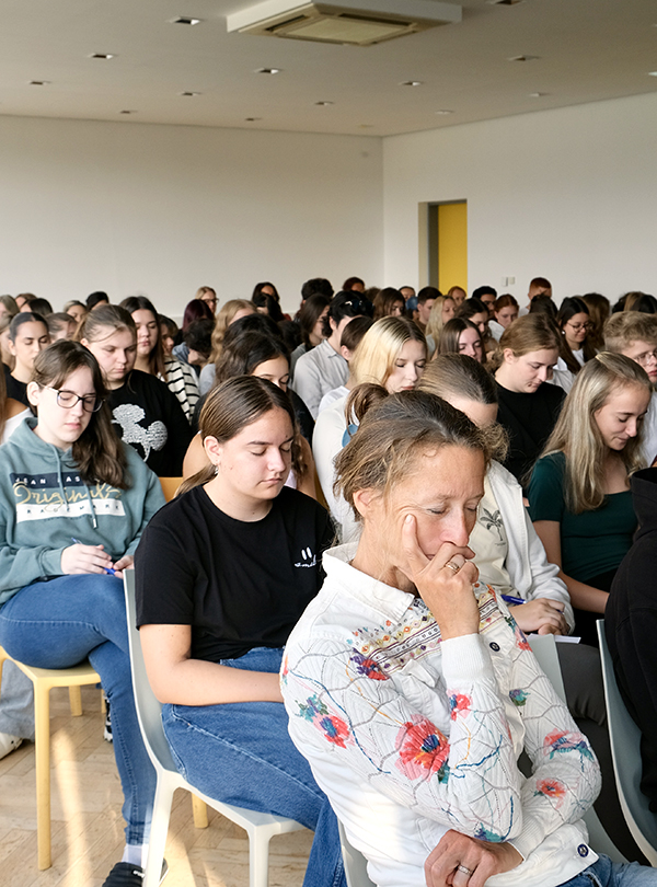 Schüler/innen im Festsaal mit geschlossenen Augen
