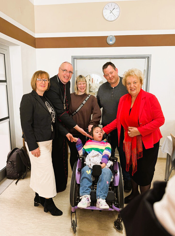 Gruppenbild mit betroffenem Mädchen im Rollstuhl