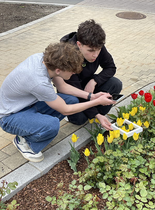 Schüler knien vor Blumenbeet