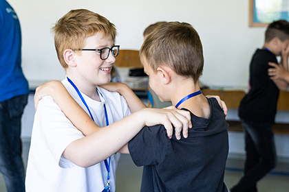 Schüler halten sich an Schulter fest, gegenüberliegend
