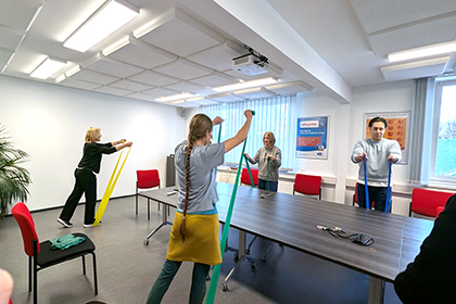 Büroangestellten turnen mit Terrabändern