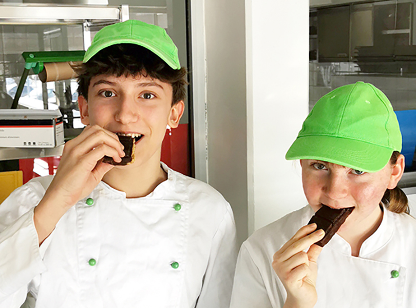 Zwei Schüler beißen in selbstgemachte Schokolade