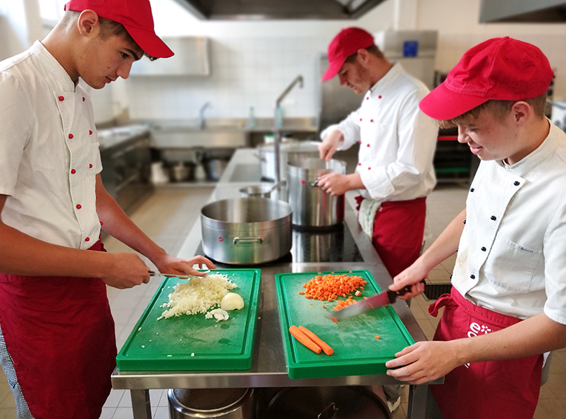 Zwei Schüler beim Schneiden von Gemüse