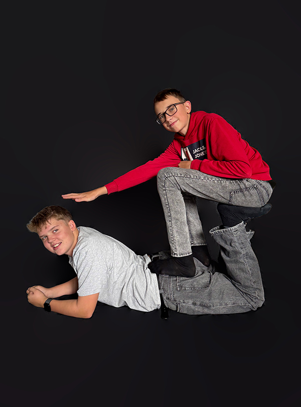 zwei Schüler posieren vor dem schwarzen Vorhang