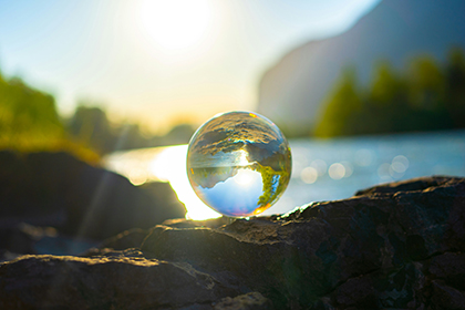 Nahaufnahme Glaskugel im Hintergrund ein See