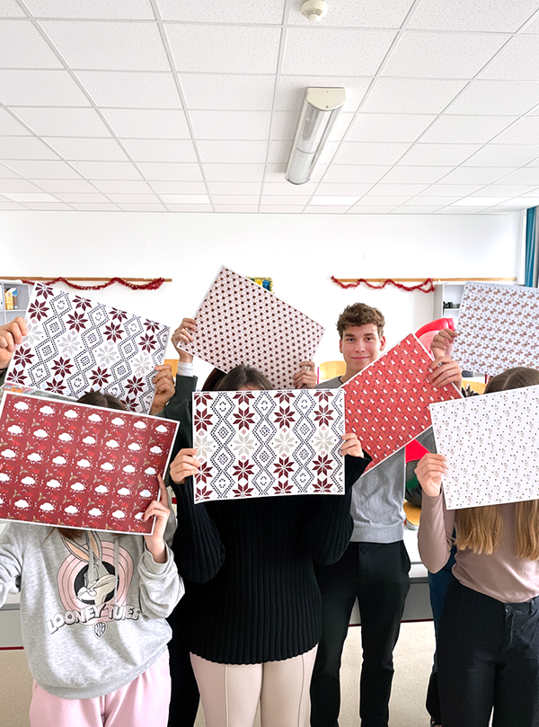 Schüler/innen halten Geschenkpapier hoch