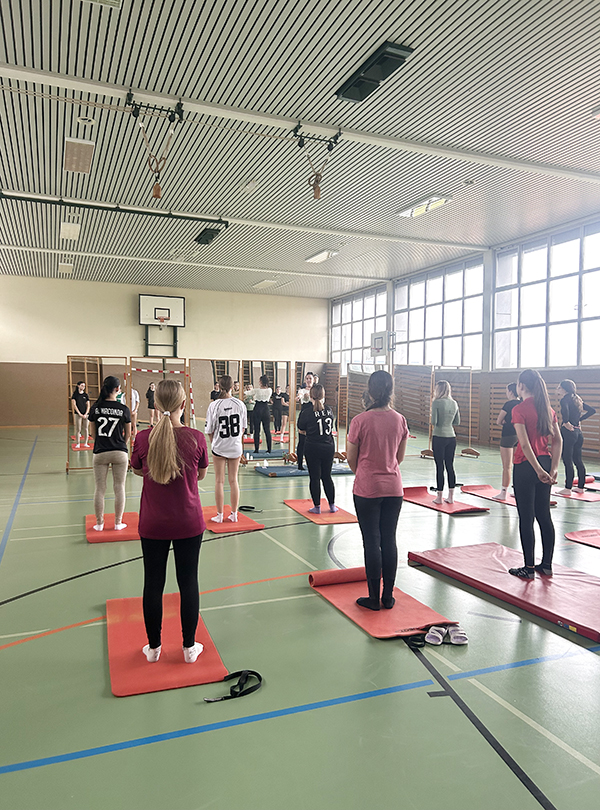 Schülerinnen turnen auf Yogamatten