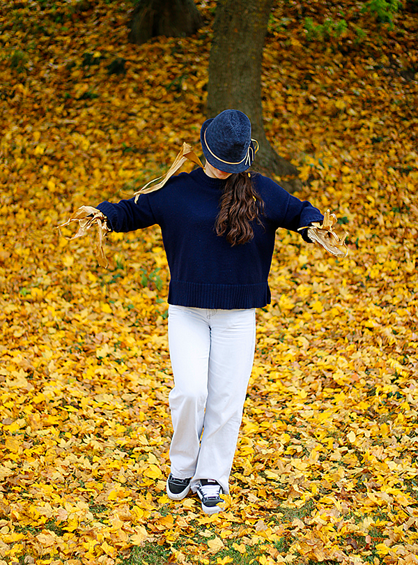 Schülerin als Vogelscheuche verkleidet vor gelben Blättern