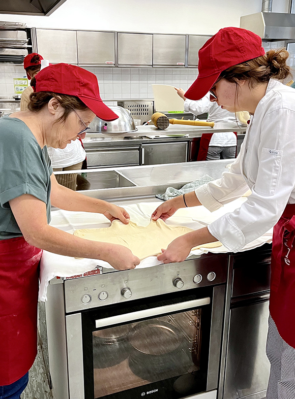 Strudelteig wird zu Zweit ausgezogen