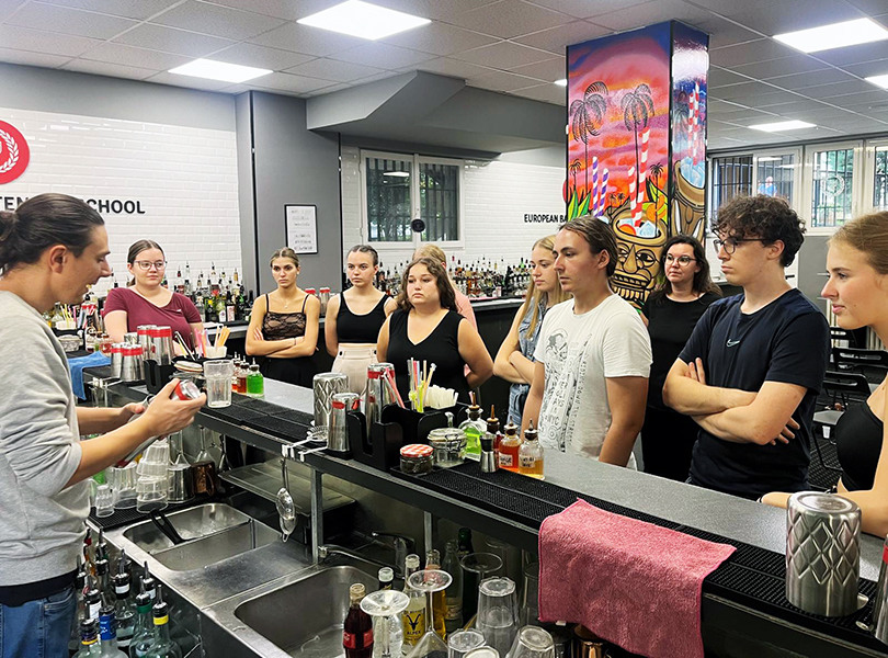 Schüler lassen sich von italienischem Lehrer in der Küche etwas erklären