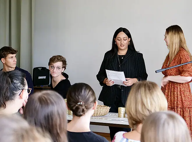 zwei Schülerinnen sprechen vor Publikum