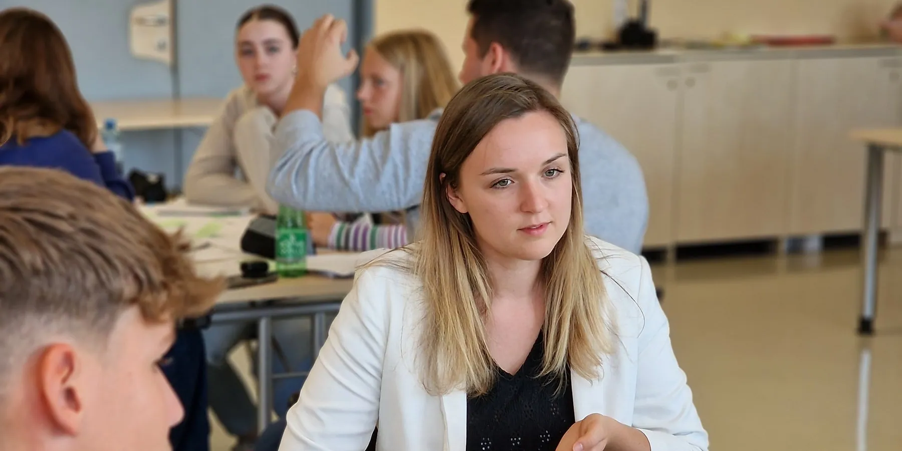 Schülerinnen und Schüler der Fachschule erarbeiten mit einer Trainerin Ideen auf einem Plakat